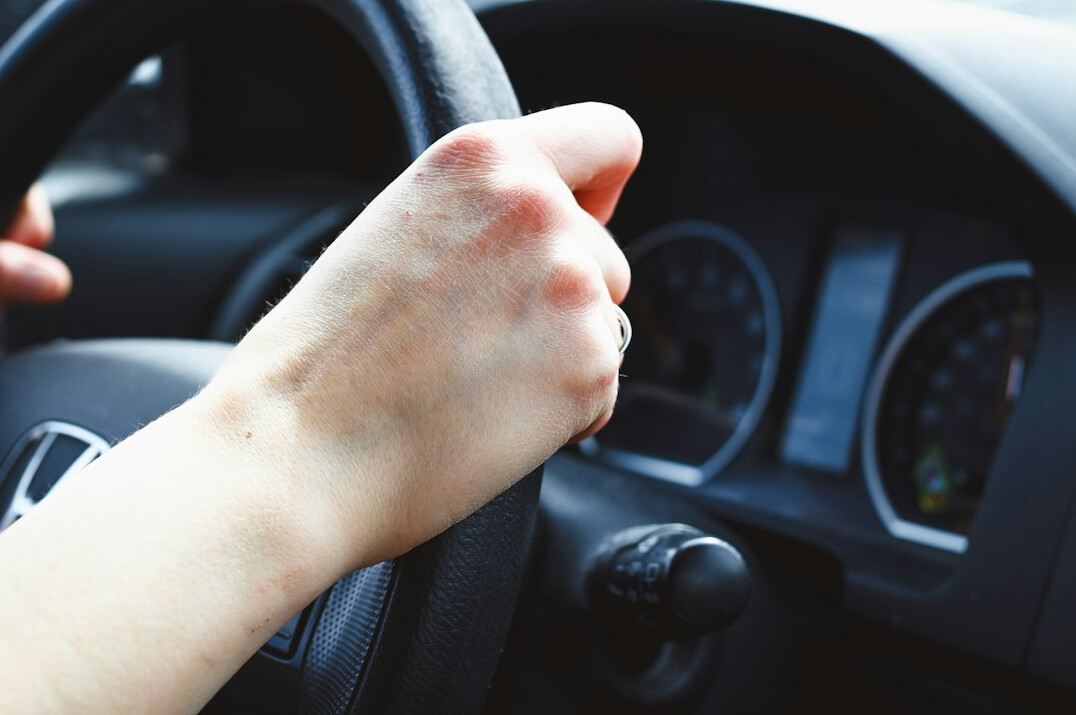 Hands holding a car steering wheel correctly
