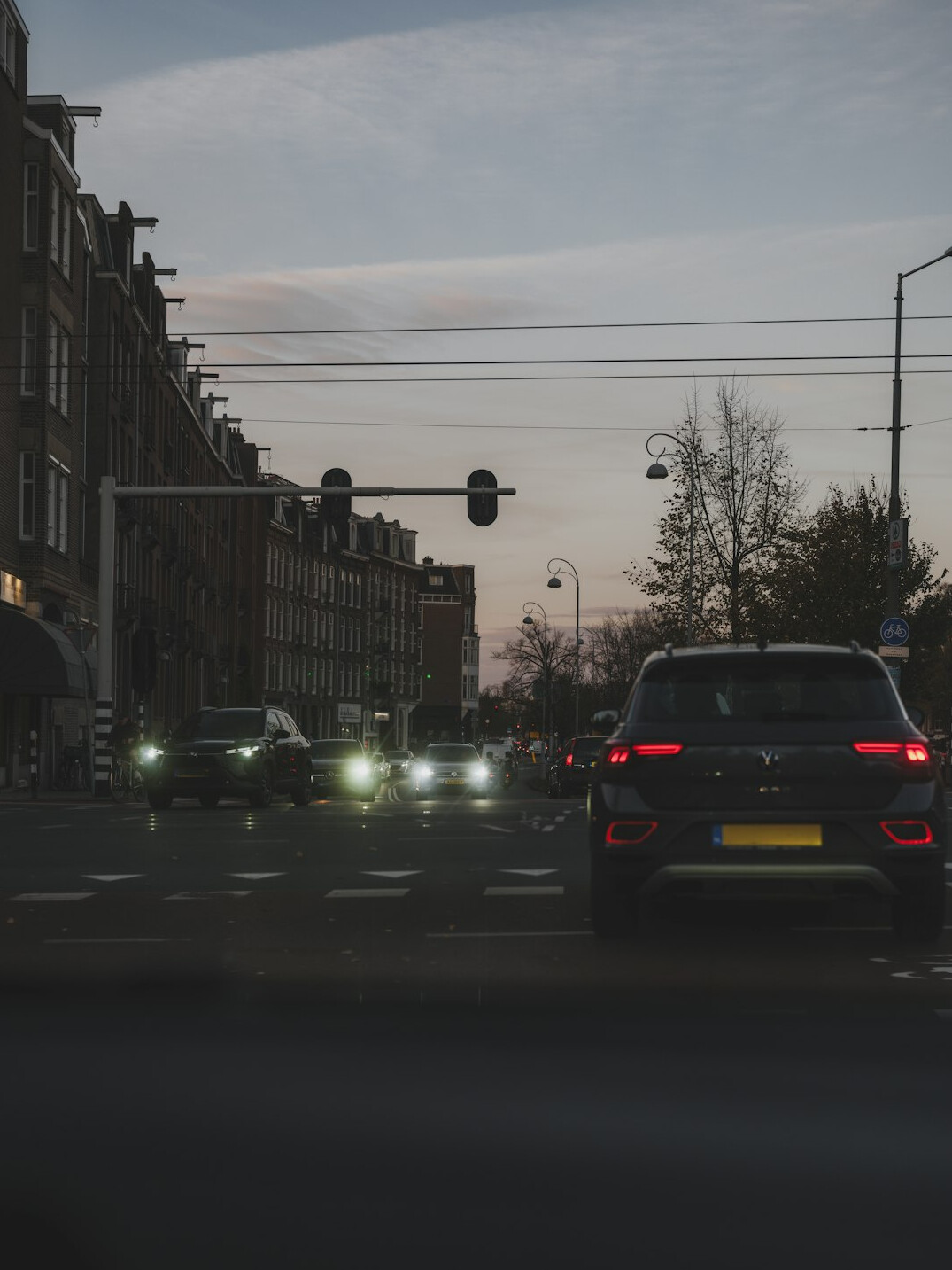 City street with cars at dusk and traffic lights